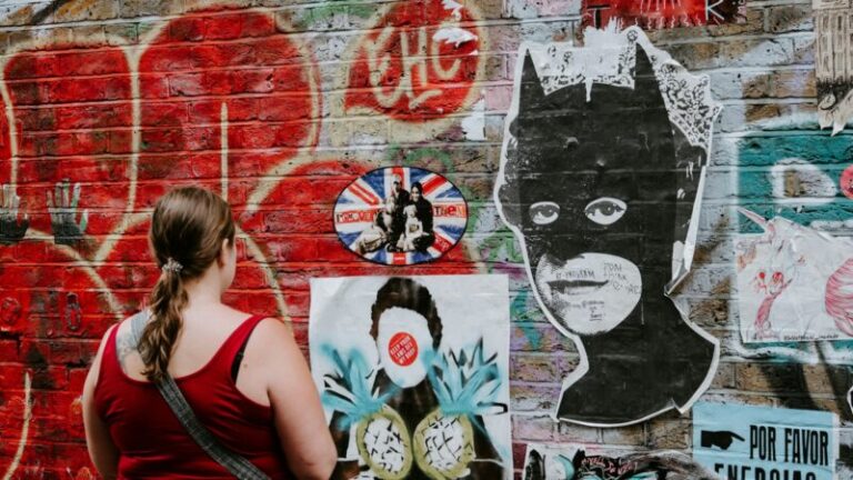 woman looking at batman graffiti wall art